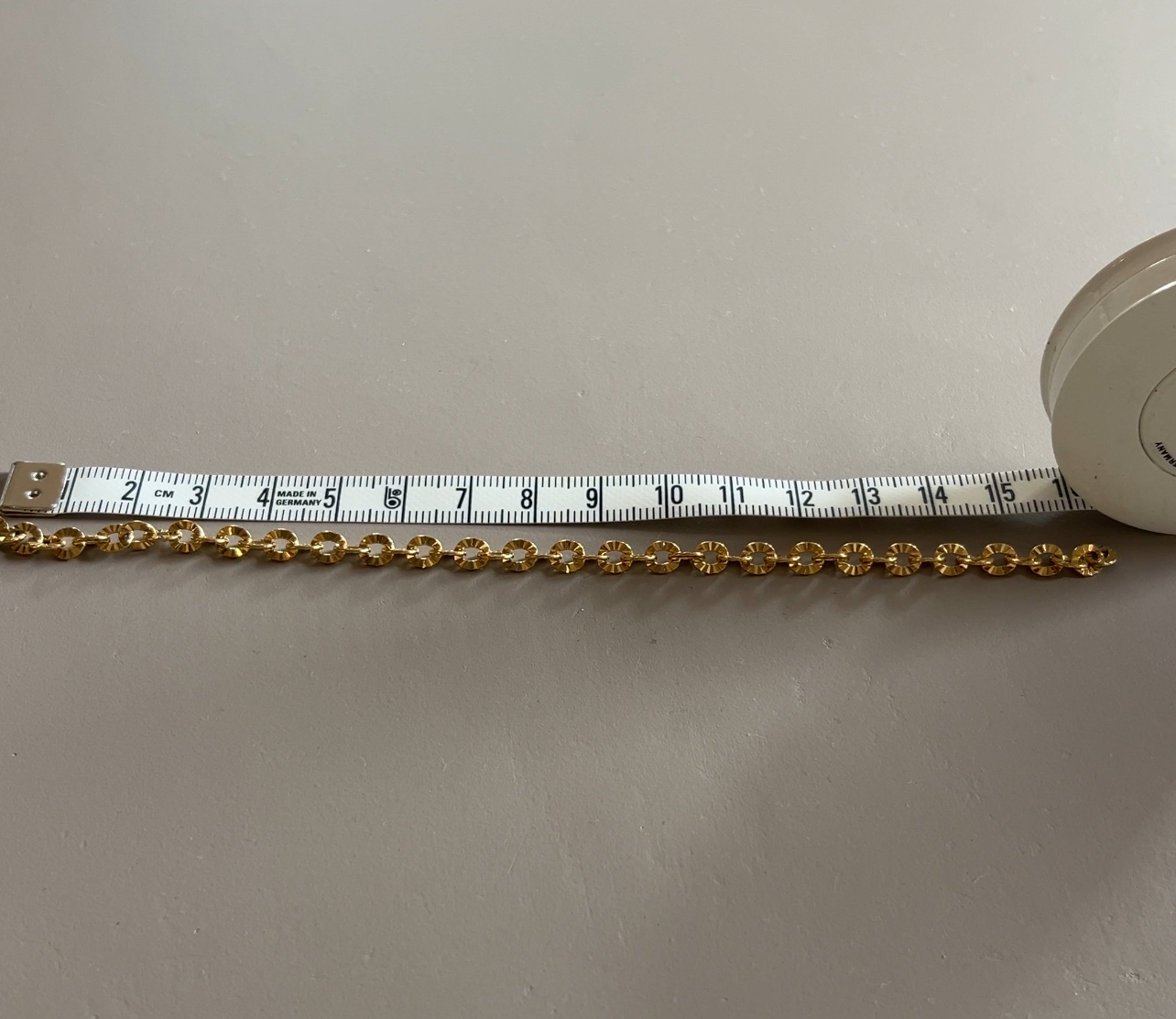 Gouden basisketting op de werktafel, met meetlint erbij